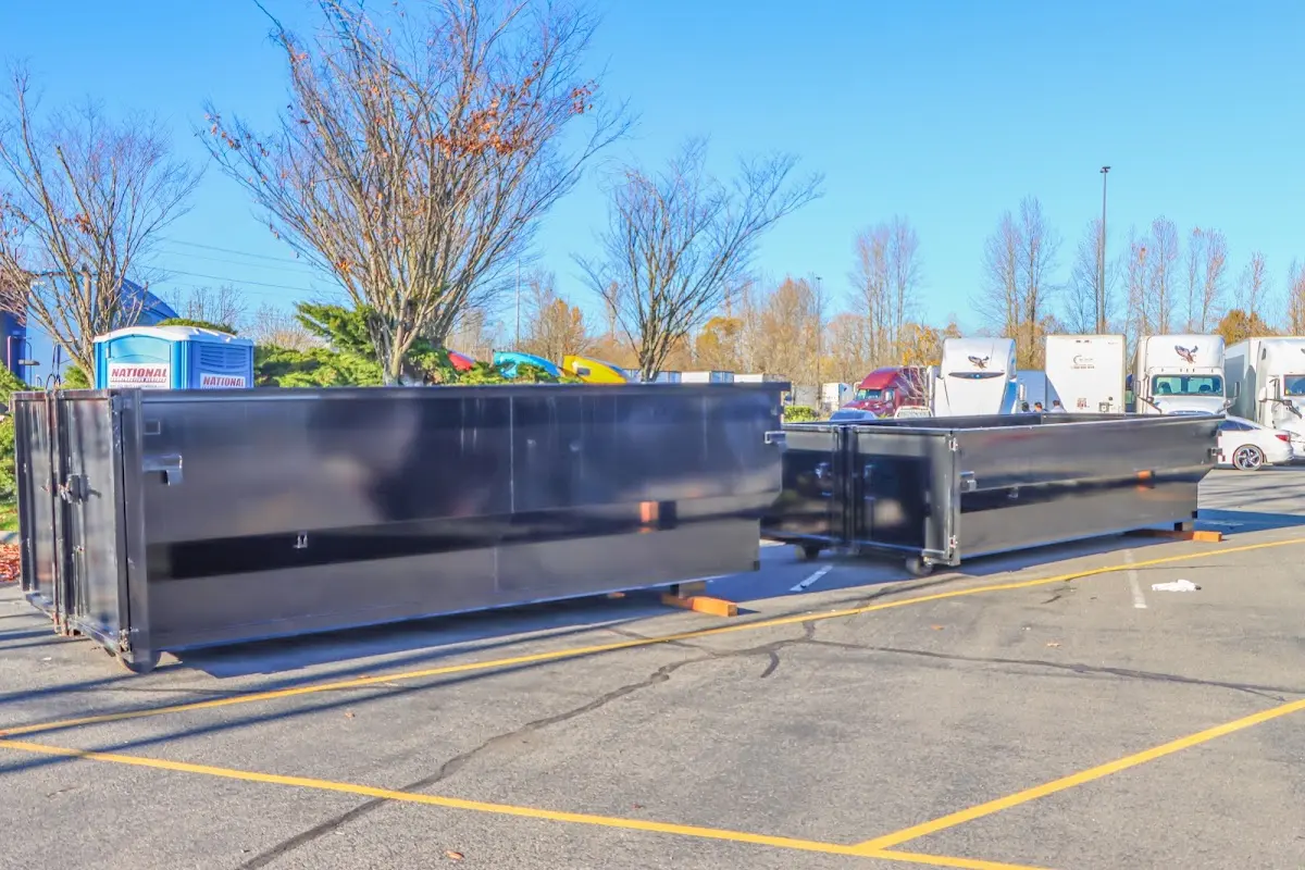 Professional dumpster rental service with roll-off container on residential driveway in West Long Branch